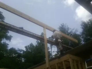 Carpenter setting a ridge beam over a new addition frame — Ice Dam Removal by Roofing Brothers in North Henderson