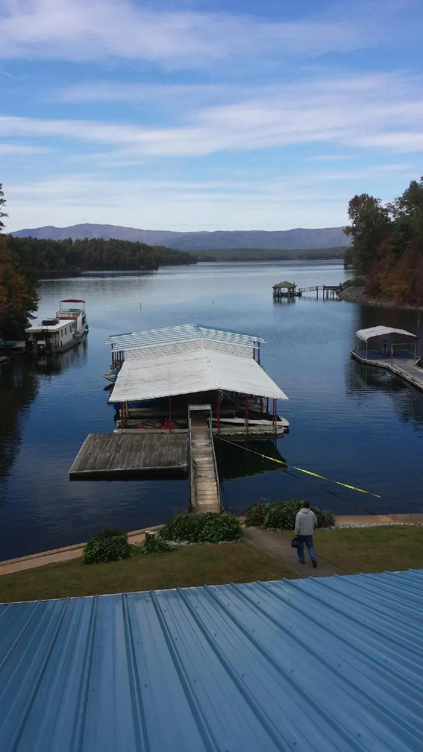 View across a lake from a newly installed blue metal roof in North Henderson