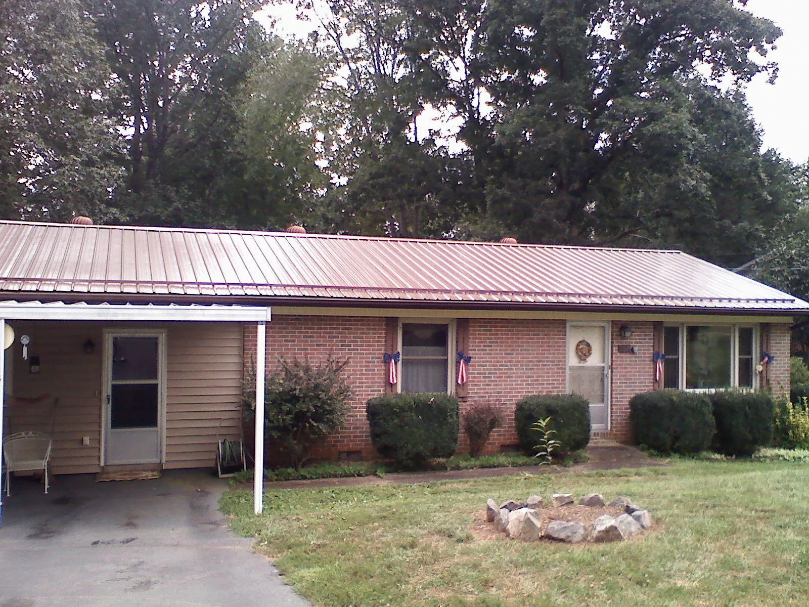 Bronze metal roof and carport on a brick ranch home — Roof Repair work by our crew in North Henderson